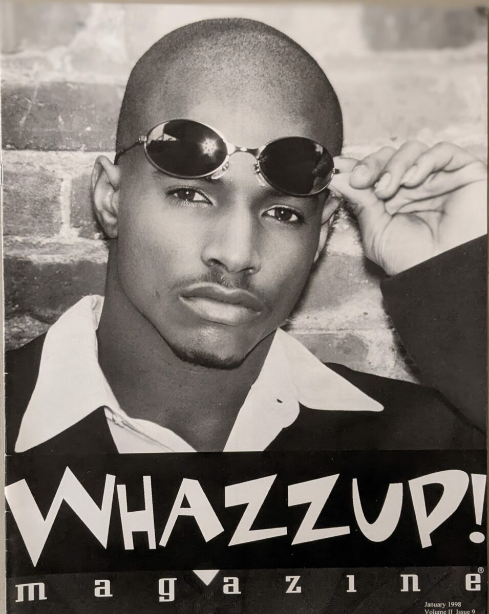 Cover of Whazzup! magazine featuring a man with raised sunglasses.